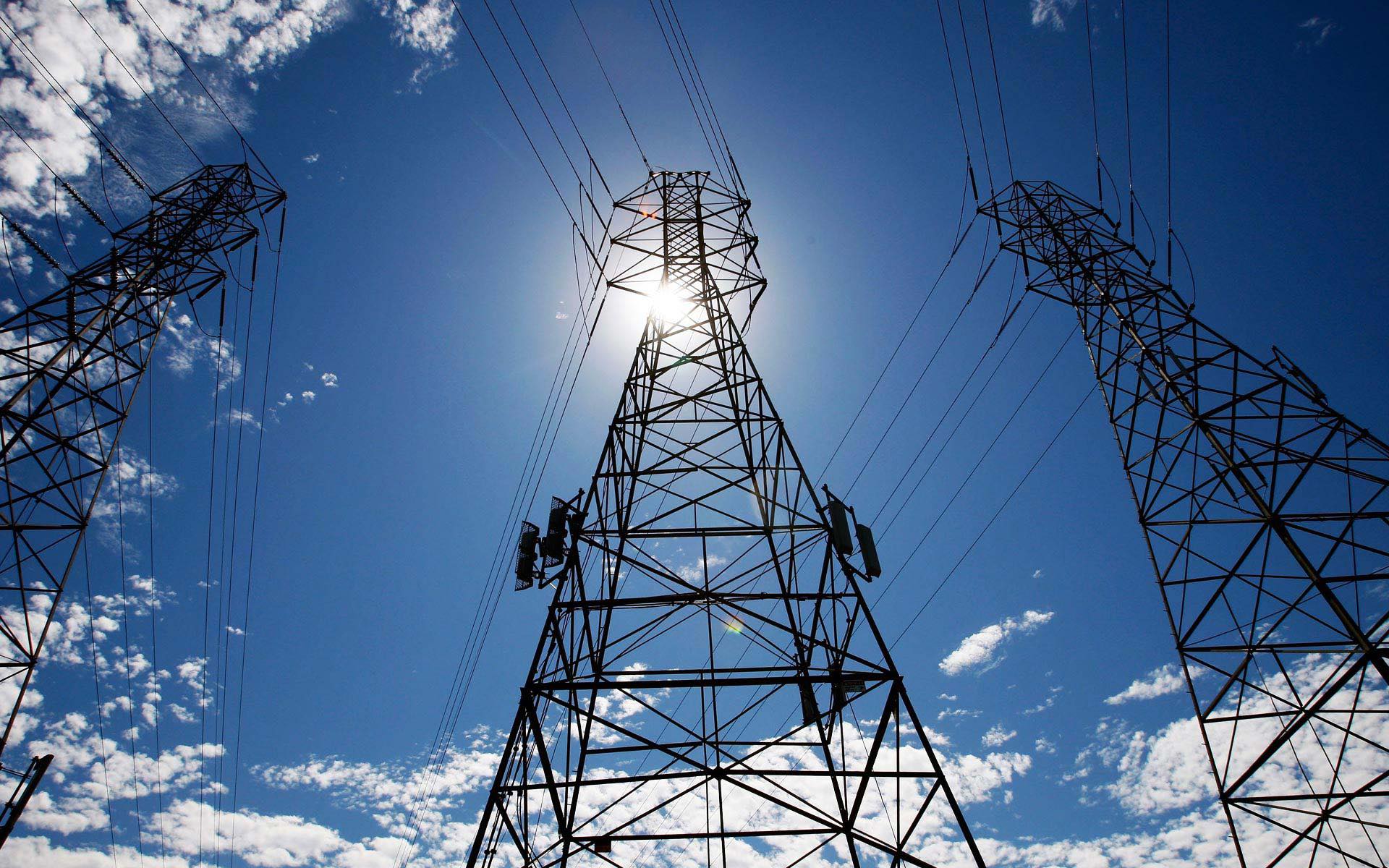 A view of some power lines and the sun.